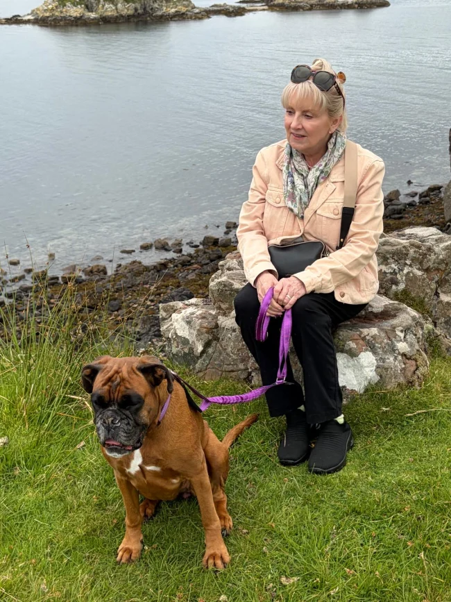 d90a4d06-fd11-41d3-a760-8d4e7b213473 Karen, Therapist in Cumbernauld, Airdrie and Online sitting on a rock with her boxer dog, Freya